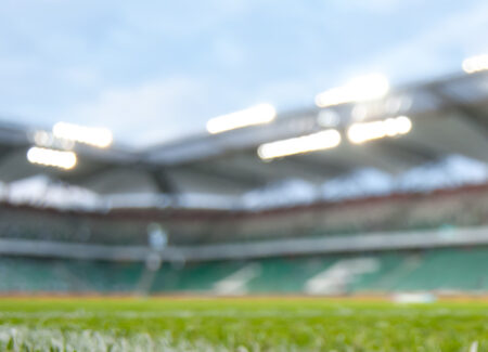 Shot of the ground of a football stadium with bleachers in the background.