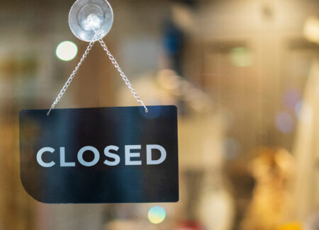 closed sign hanging outside a restaurant, store, office or other business.